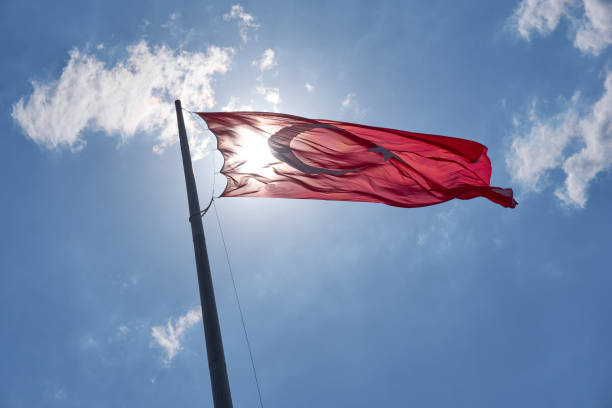 istock Turkish National Flag waving in the sky 1296669372
