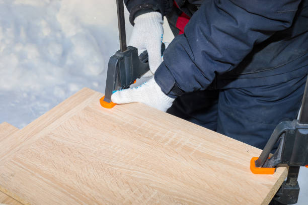 istock A man, a worker, secures the chipboard panels with two clamps. 1296670667