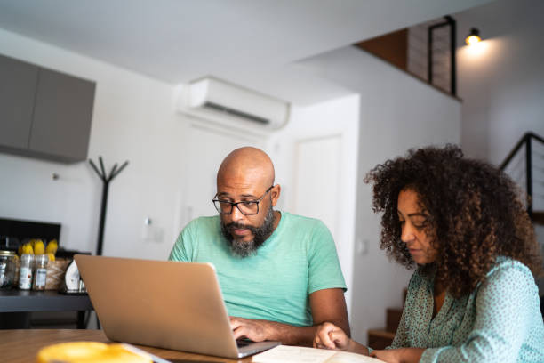 istock Couple using laptop to pay bills or shopping at home 1296671455