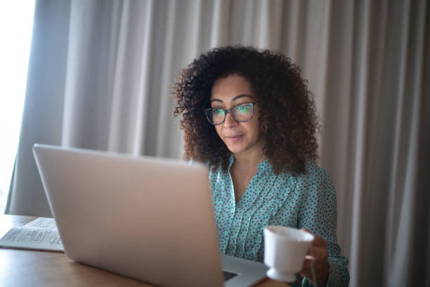 istock Business woman working from home drinking coffee 1296671480
