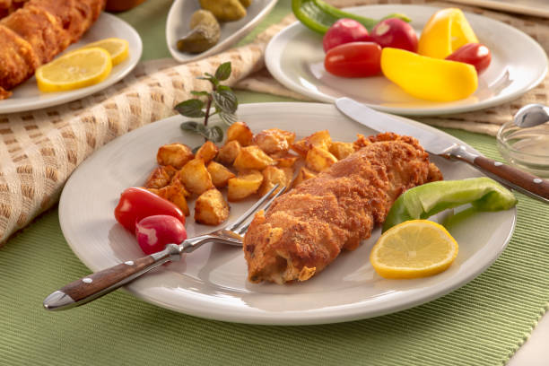 istock Fried ham roll wrapped in batter with American potatoes on a plate. 1296672117