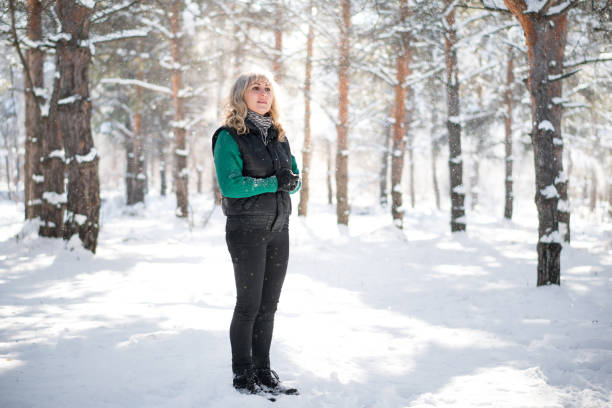 istock Woman walks in snowy forest. 1296673220