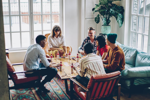 istock Trendy hipster guys feeling comfort during together weekend for practice blackjack skills, youthful group of young diverse players creating strategy for casino board games with cards and chips 1296673230