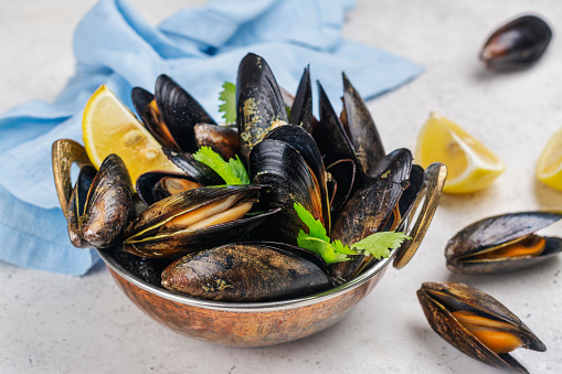 Delicious cooked seafood mussels with lemon and parsley. Clams in the shells. Copy space