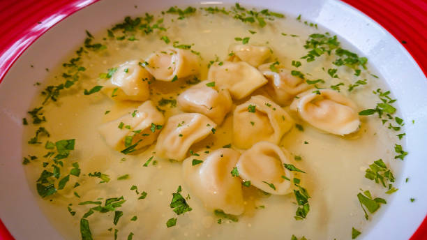 istock Red plate with broth and dumplings on the table 1296676458