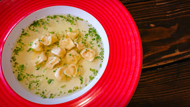 istock Red plate with broth and dumplings on the table 1296676488