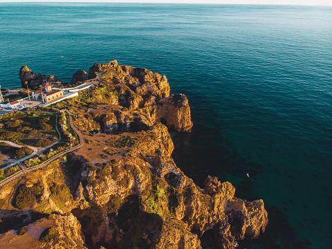 Amazing Drone Shot of Beautiful Ponta da Piedade with the Farol da Ponta da Piedade and Lagos in the back, Portugal