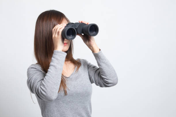 istock Young Asian woman with binoculars. 1296677884