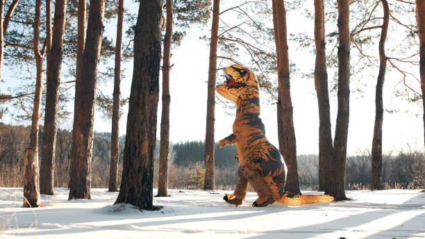istock Dinosaur Tirex runs in winter through the forest on a sunny day 1296678770