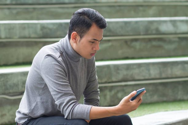 istock frustrated, surprised, upset, unhappy man using smartphone 1296679458
