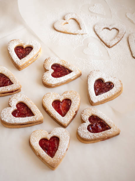 istock Homemade heart shaped cookies with raspberry jam on white background 1296679551