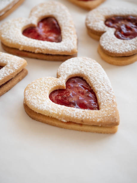 istock Homemade heart shaped cookies with raspberry jam on white background 1296679574
