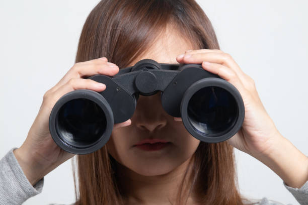 istock Young Asian woman with binoculars. 1296679707