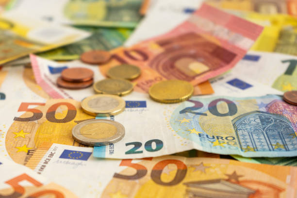 close up view of european union banknotes and coins. selective focus on the two euro coin - european union euro note european union currency paper currency currency imagens e fotografias de stock