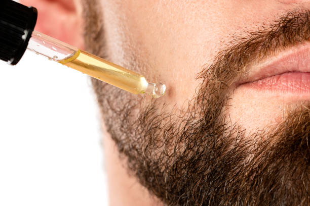 viso maschile e pipetta con un olio per una crescita della barba - barba foto e immagini stock