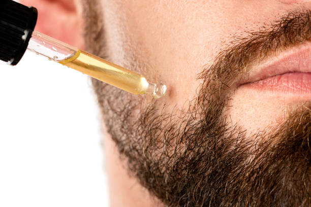 male face and pipette with a oil for a beard growth - stubble imagens e fotografias de stock