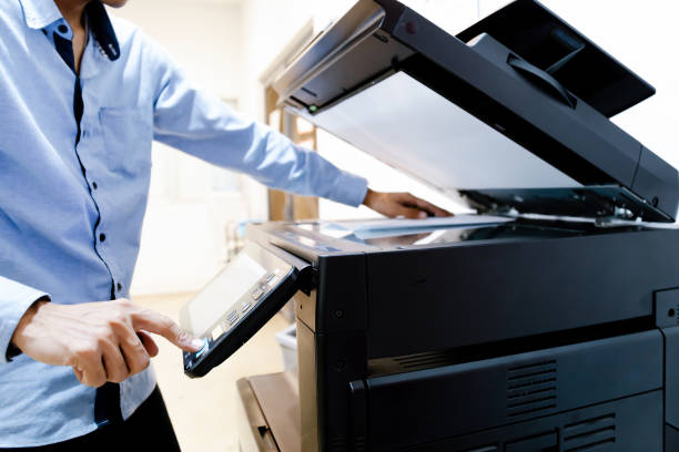 istock Bussiness man Hand press button on panel of printer, printer scanner laser in office copy machine supplies start concept. 1296681940