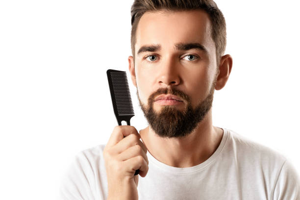 istock Handsome well groomed man combing his beard 1296682093
