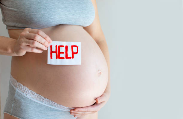 istock Pregnant belly with Help text. Concept due to the coronavirus epidemic, miscarriage, abortion, difficult pregnancy, motherhood, anxiety, thinking about covid-19 pandemic and illness 1296682399