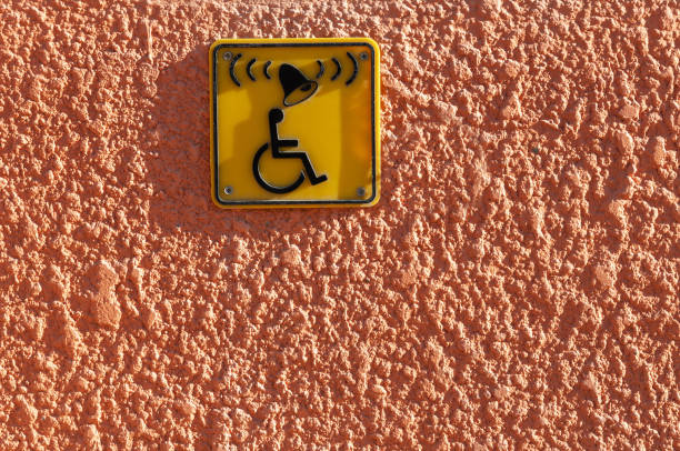 Invalid on wheelchair and ring bell sign on the wall. Disabled people help with copy space for text