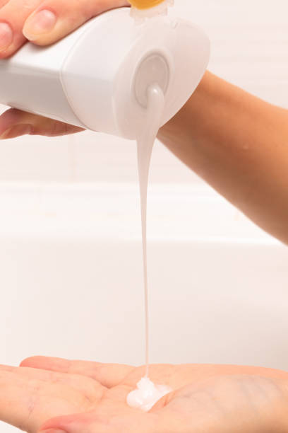 istock female hands pour shampoo into the palm from a bottle in a bathroom on a light background 1296684689