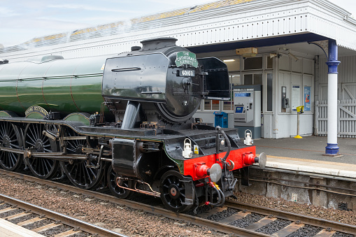 Queensferry, Scotland - May 20, 2018: Flying Scotsman steam train passing station Dalmeny in Queensferry near Forth Bridge in Scotland