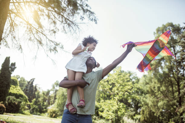 istock Dark-skinned man and his little daughter playing with a kite 1296686362