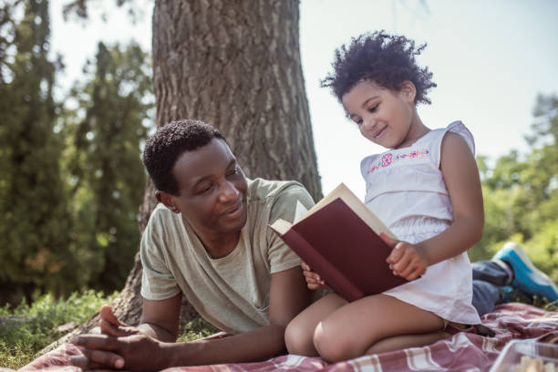 istock African american man and his kid reading a book together 1296686490