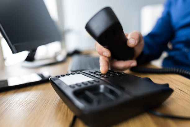 istock Businessman's Hand Dialing Telephone Number To Make Phone Call 1296686821
