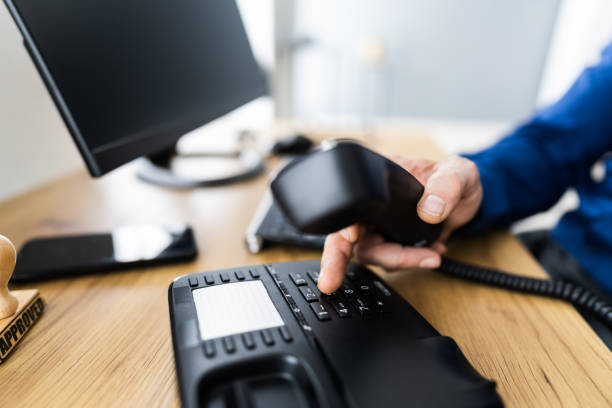 istock Businessman's Hand Dialing Telephone Number To Make Phone Call 1296686828