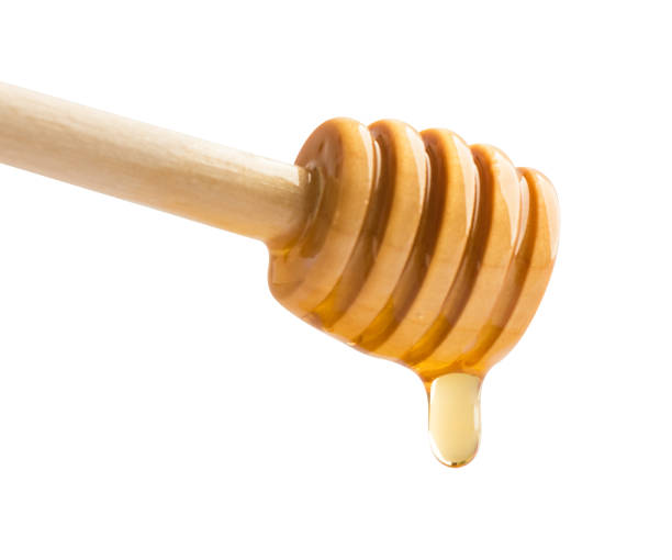 istock Honey dripping off a wooden honey dipper. 1296687601