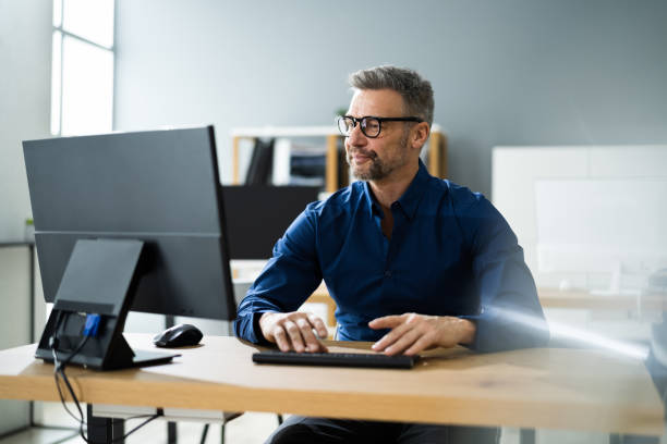 Businessman Using Business Computer In Office Businessman Using Business Computer In Office Or Workplace desktop pc stock pictures, royalty-free photos & images