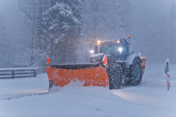 istock Snow plow tractor clearing snowy road during a snowstorm 1296687977