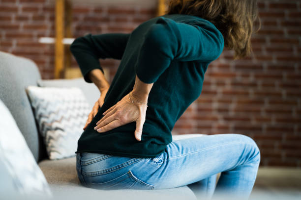 woman with back pain and ache - dor de costas imagens e fotografias de stock