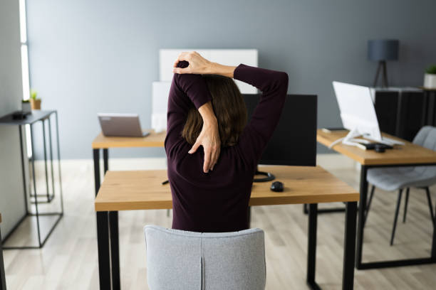 istock Stretching Exercise At Office Desk. Woman 1296689144