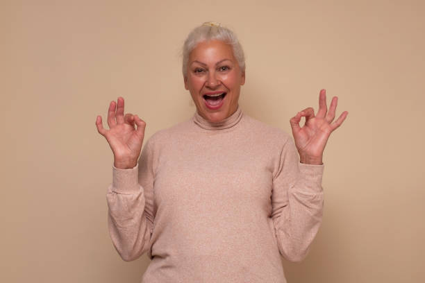 istock Senior woman doing ok gesture with hand smiling approving your choice. 1296691966
