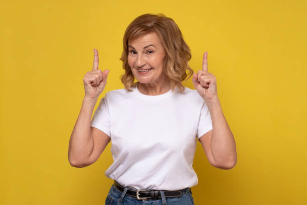 istock Senior smiling woman pointing up giving advice. 1296693033