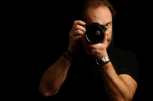 man with mirrorless camera. Black background