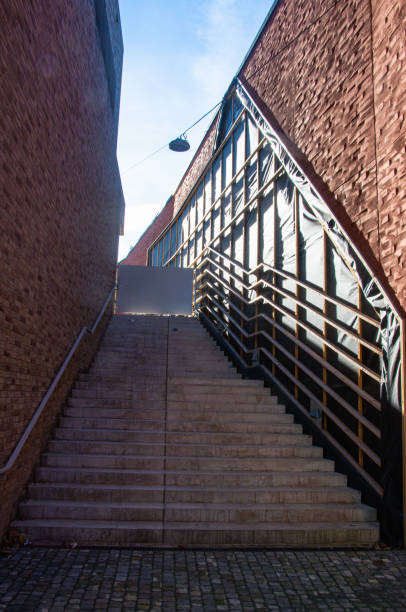 istock Narrow stone staircase between red brick walls 1296693267