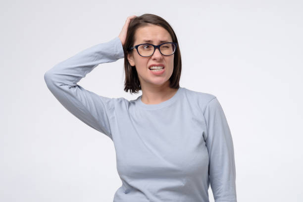 istock Mature woman with glasses scratching head, thinking daydreaming deeply about something 1296695269