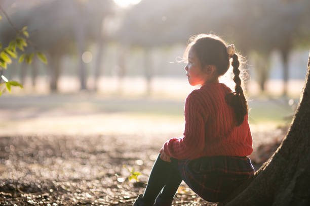 Girl sitting on a tree trunk