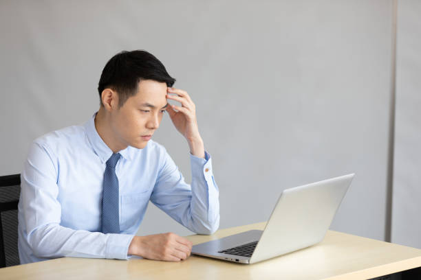 istock stressed asian businessman feeling sick and tried in office 1296696700