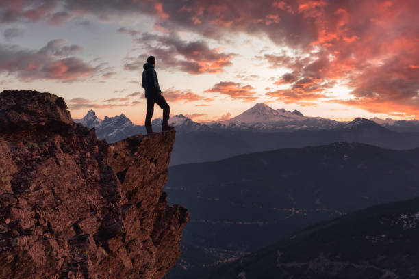 istock Adventurous man is standing on top of the mountain 1296696893