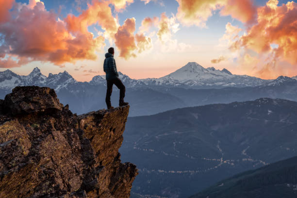 istock Adventurous man is standing on top of the mountain 1296696921