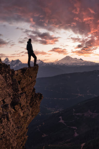 istock Adventurous man is standing on top of the mountain 1296696927