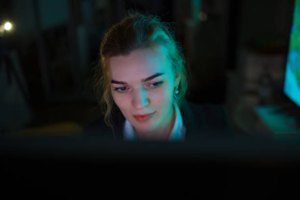 istock Young business woman office worker working by PC at night 1296699006