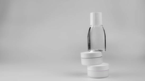 istock white containers with cosmetics (face cream, hand cream, miscellaneous water) on a white background, arranged vertically 1296699383