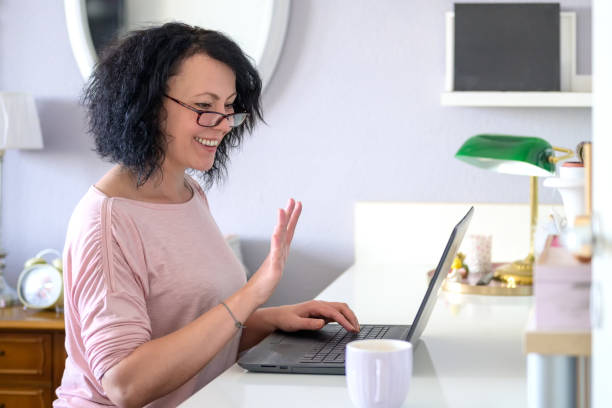 istock Woman waving to the computer 1296700672