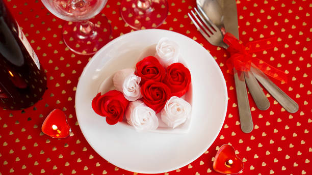 istock A white plate with wine, a knife and fork on a bright red background 1296701566