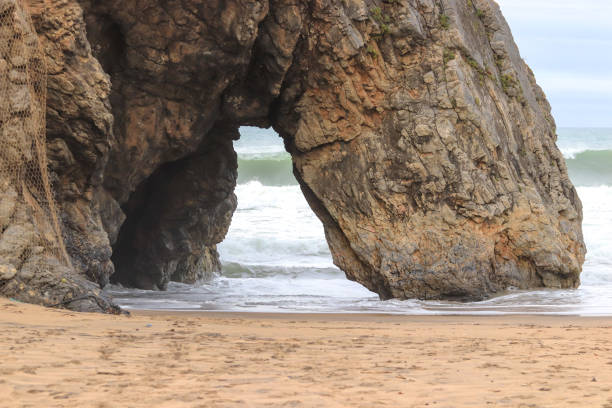 istock Beautiful stone natural arche. Rock formation in a beach with ocean in background. 1296701801